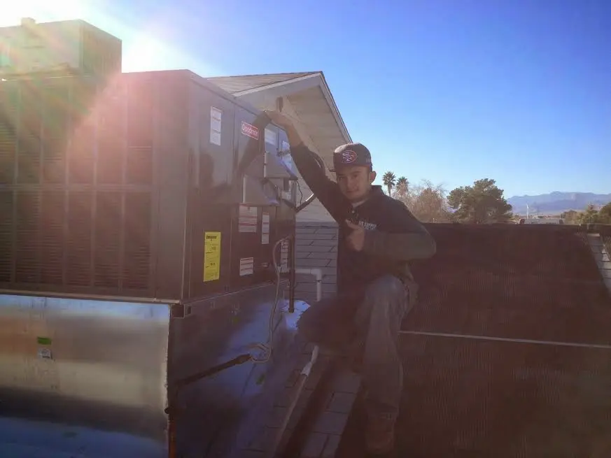 HVAC technician performing Heat Pump Repair on a rooftop unit in Avon Park